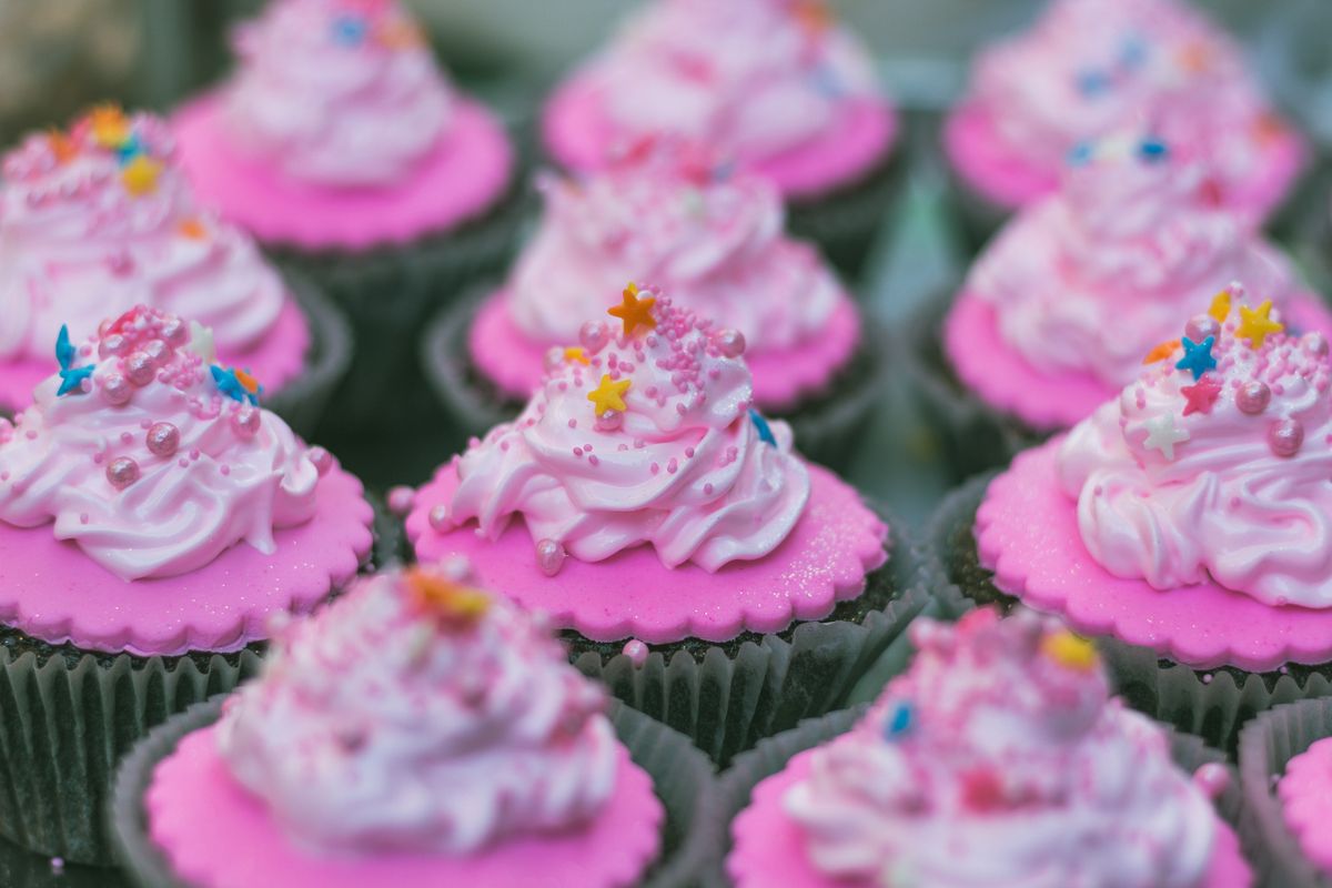 Cupcakes rosados recién horneados con chispas de colores